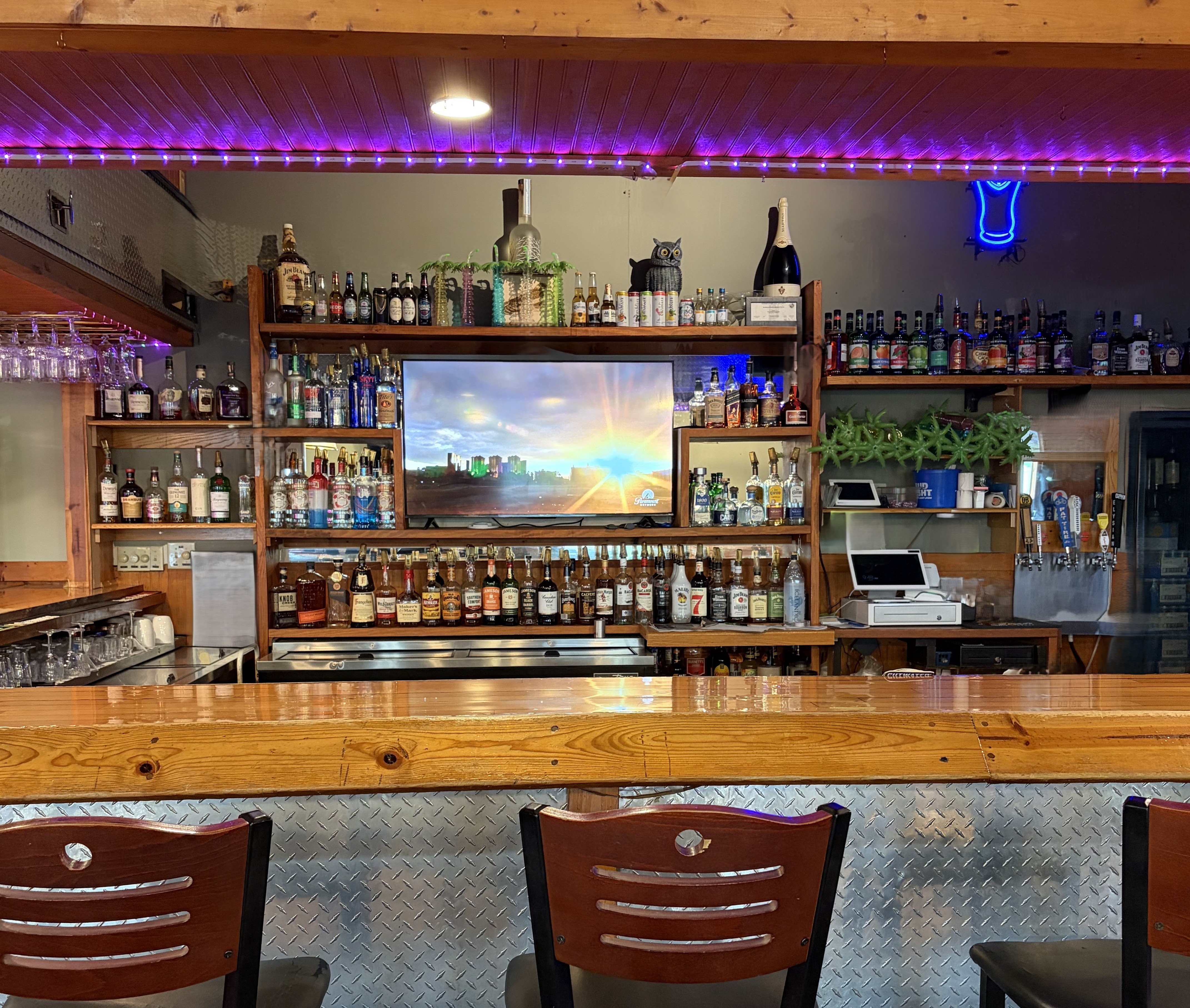 The NightJar Pub bar with wood counters, bottles, taps, and bar chairs.